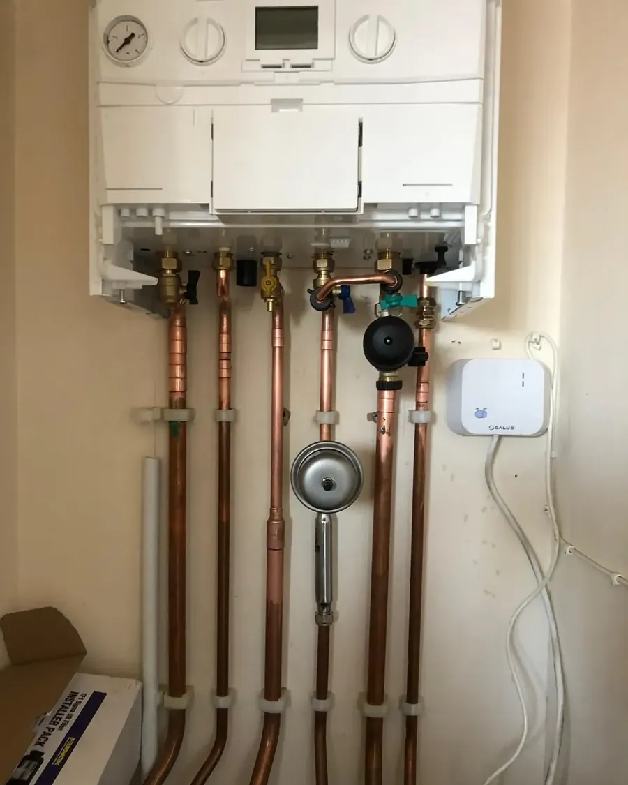 Boiler pipework with a magnetic system filter and wireless thermostat receiver fitted underneath a combi boiler