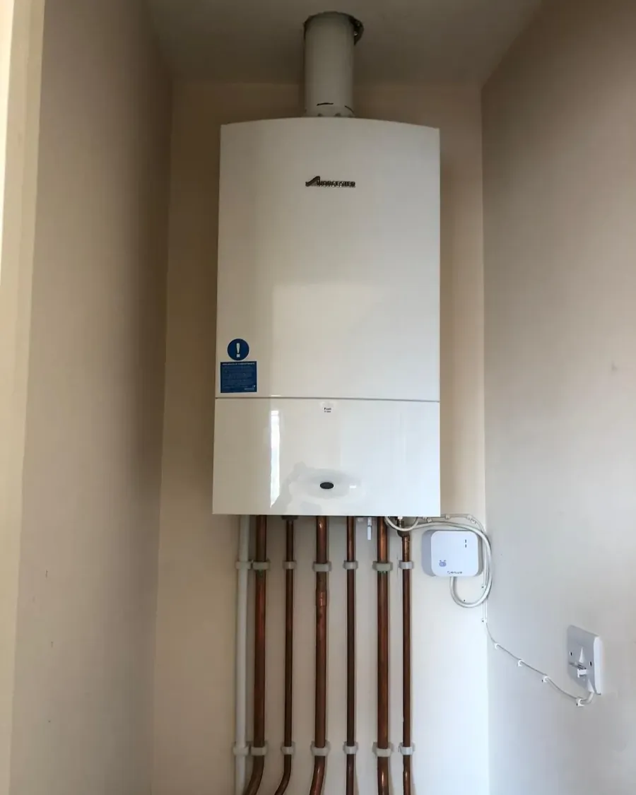 Newly installed Worcester Bosch combi boiler with neat copper pipework and a wireless thermostat receiver